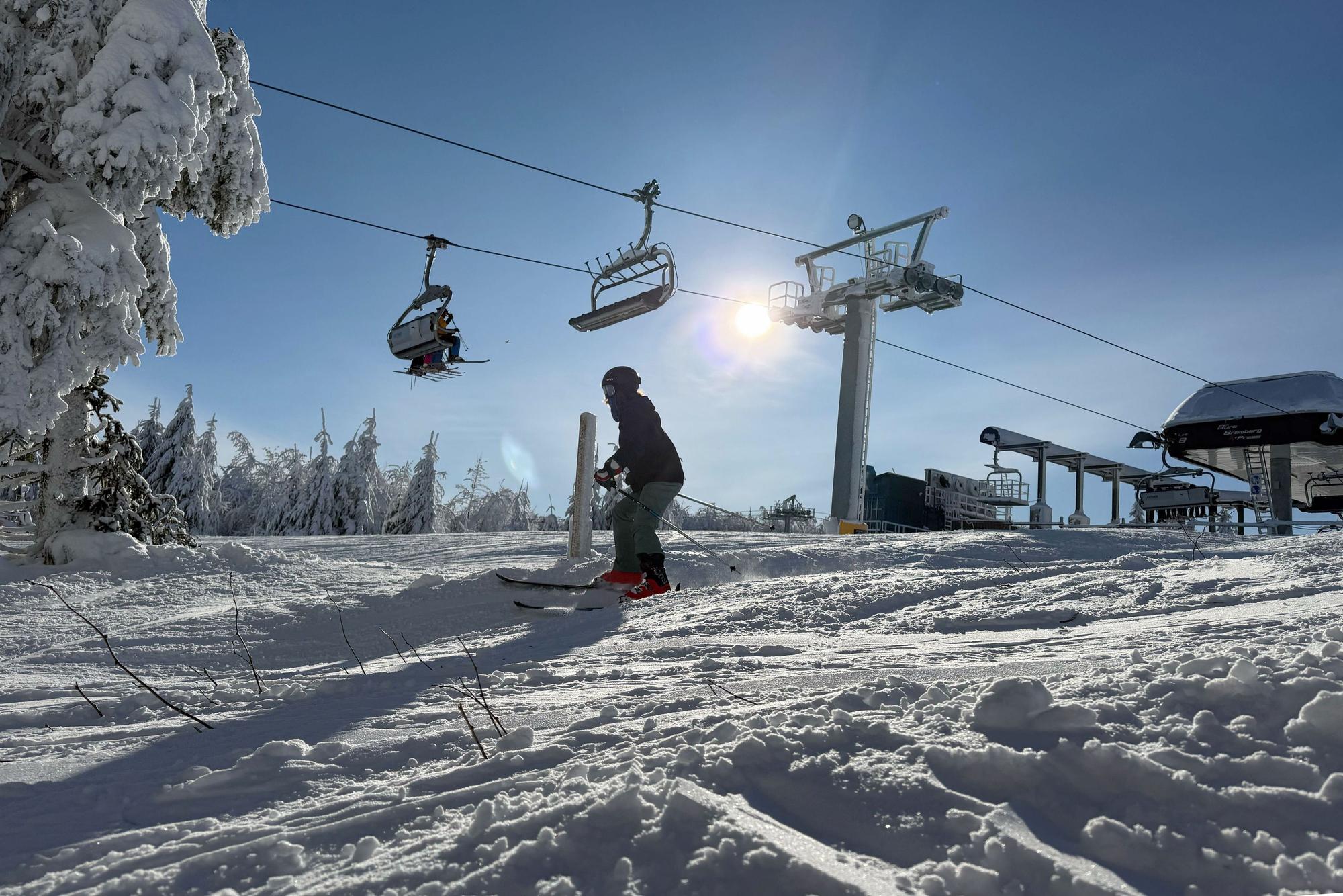 Ein Skifahrer fährt im Skigebiet Winterberg an einem Skilift vorbei.