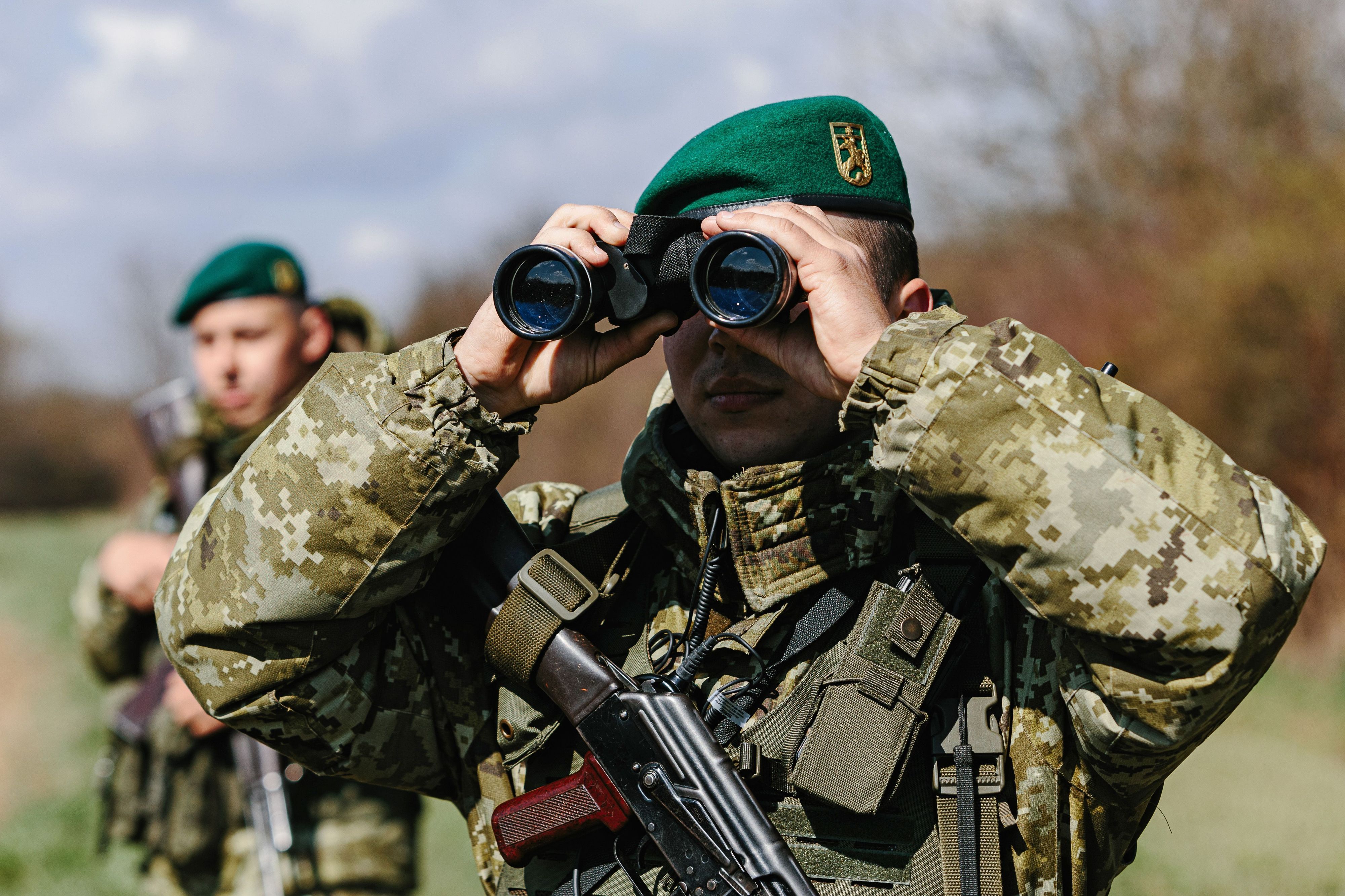 Ein ukrainischer Soldat der Grenzschutzeinheit Kosyno sucht mit einem Fernglas die Umgebung ab.