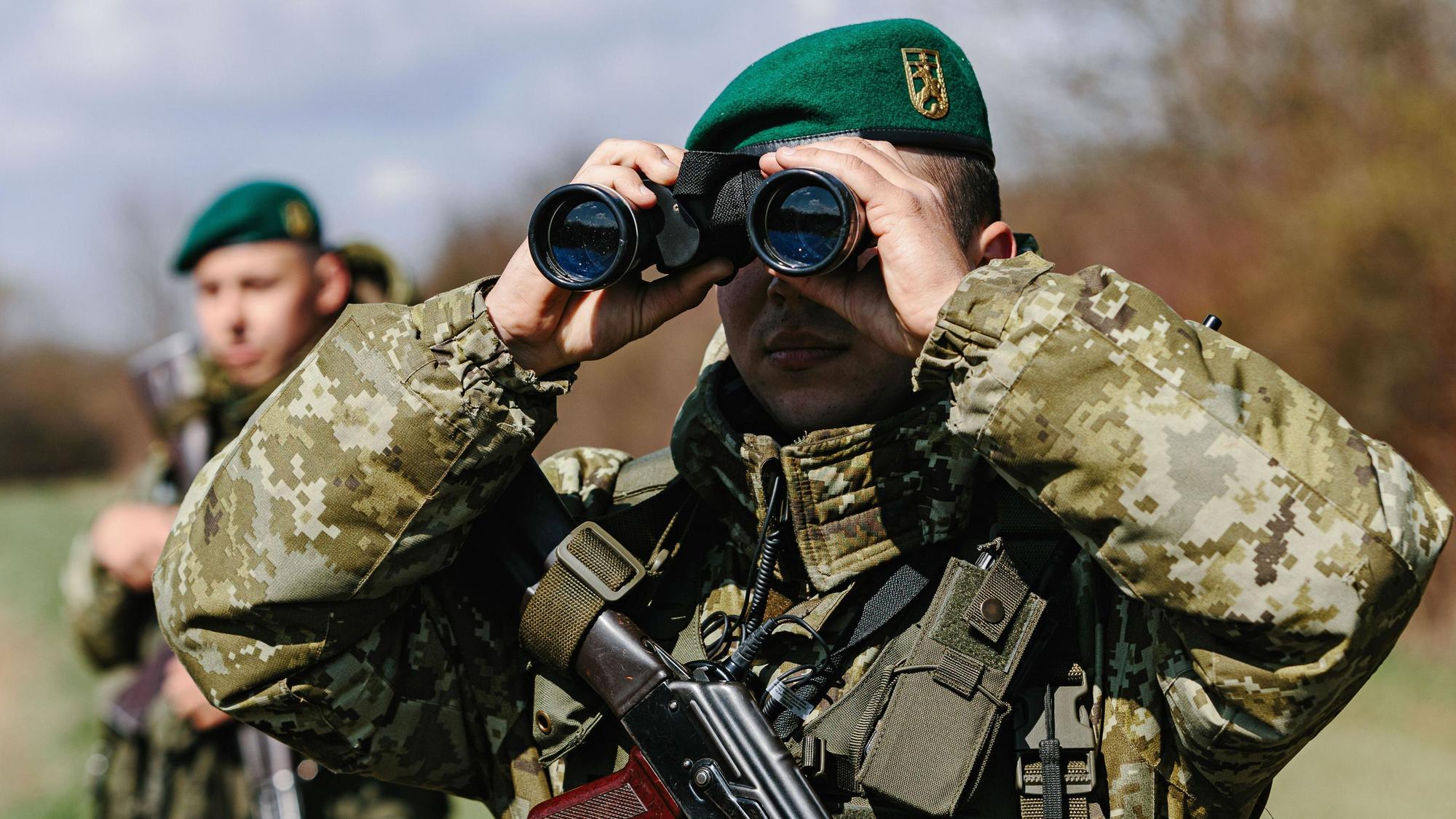 Ein ukrainischer Soldat der Grenzschutzeinheit Kosyno sucht mit einem Fernglas die Umgebung ab.