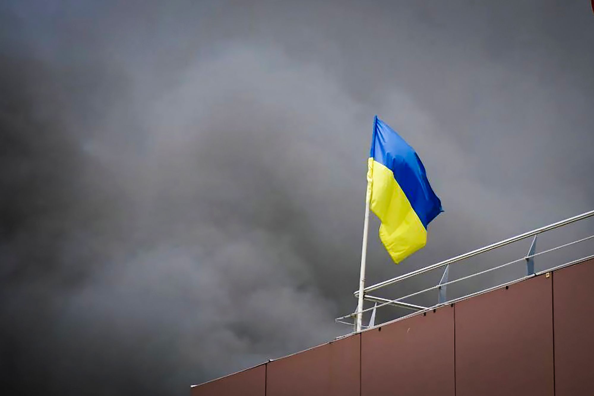HANDOUT - 03.07.2024, Ukraine, Dnipro: Auf diesem von der Regionalverwaltung Dnipropetrowsk veröffentlichten Foto weht die ukrainische Flagge, während nach einem russischen Raketenangriff Rauch aufsteigt. (zu dpa: «Ukraine: Tote und Verletzte nach russischen Angriffen») Foto: Uncredited/Dnipro Regional Administration/AP/dpa +++ dpa-Bildfunk +++