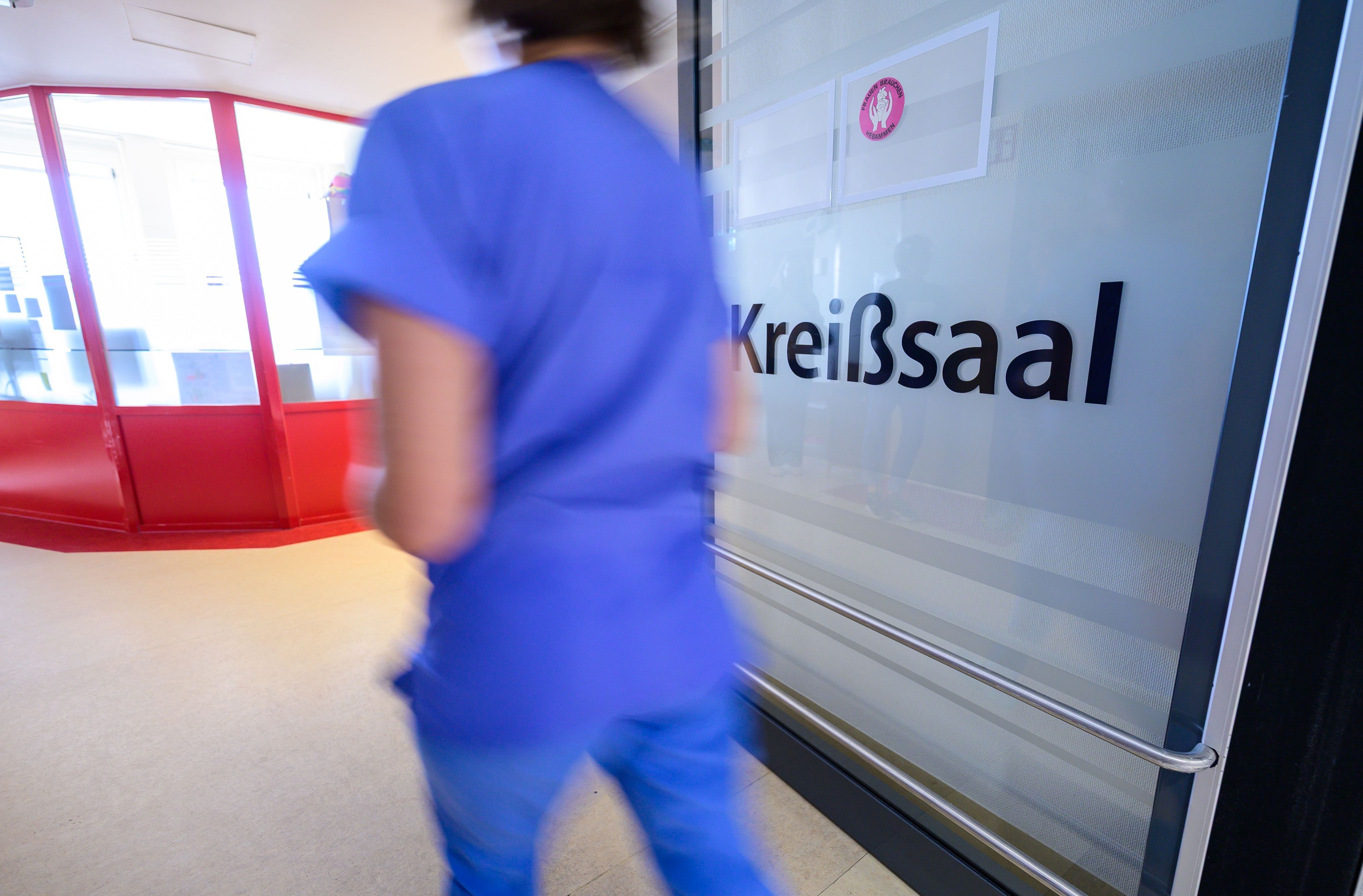 „Kreißsaal“ steht auf einer Tür in einem Geburtszentrum. In NRW ist die Zahl der Geburten rückläufig.