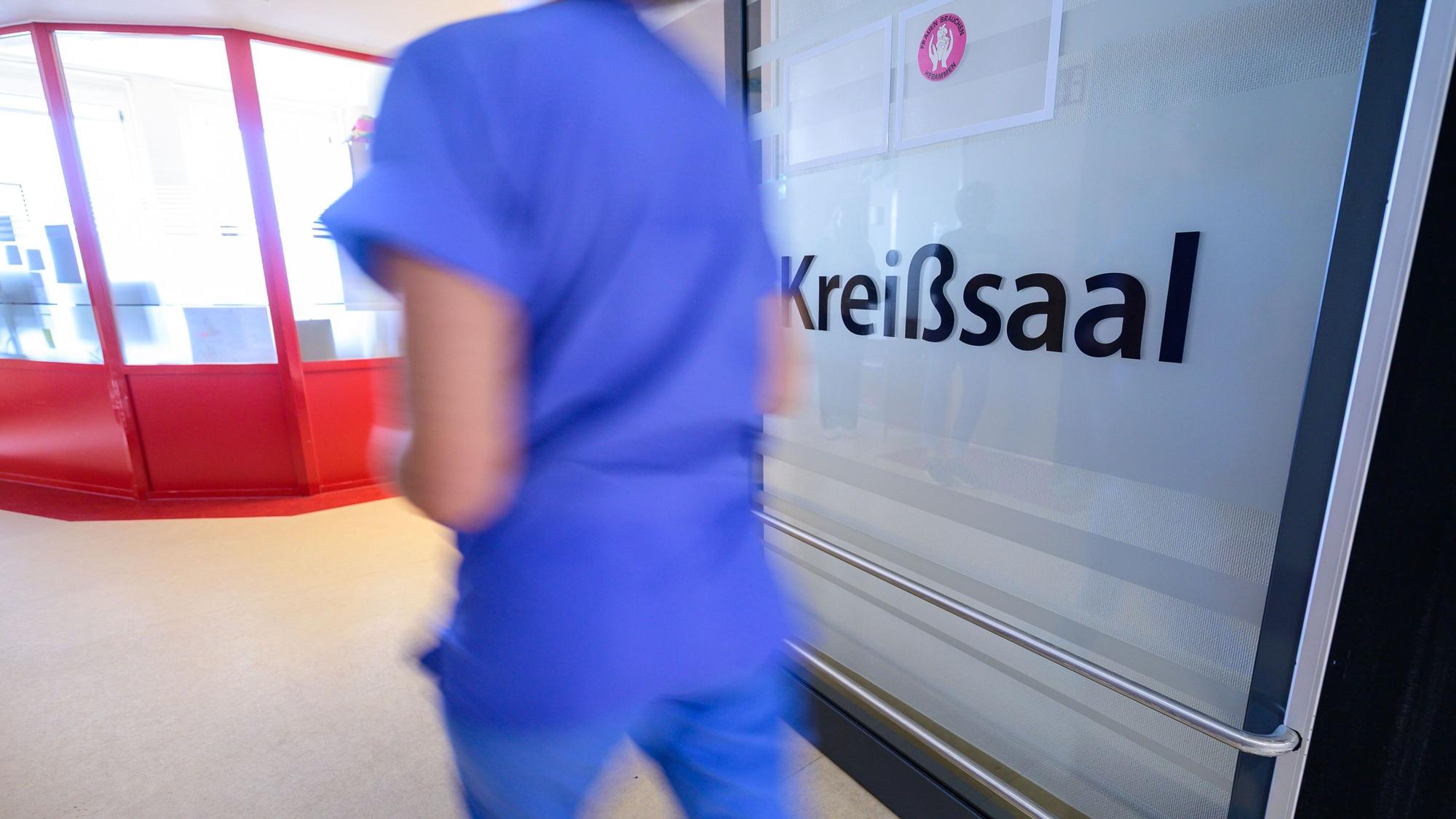 „Kreißsaal“ steht auf einer Tür in einem Geburtszentrum. In NRW ist die Zahl der Geburten rückläufig.