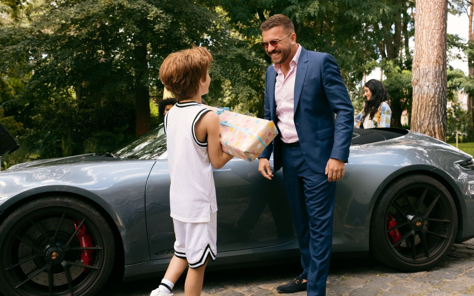 Onkel Timo (Edin Hasanović, rechts) ist der Beste! Geburtstagskind Theo (Levin Wopp) kann es nicht erwarten, sein Geschenk auszupacken. (Bild: Nadja Klier/Netflix)