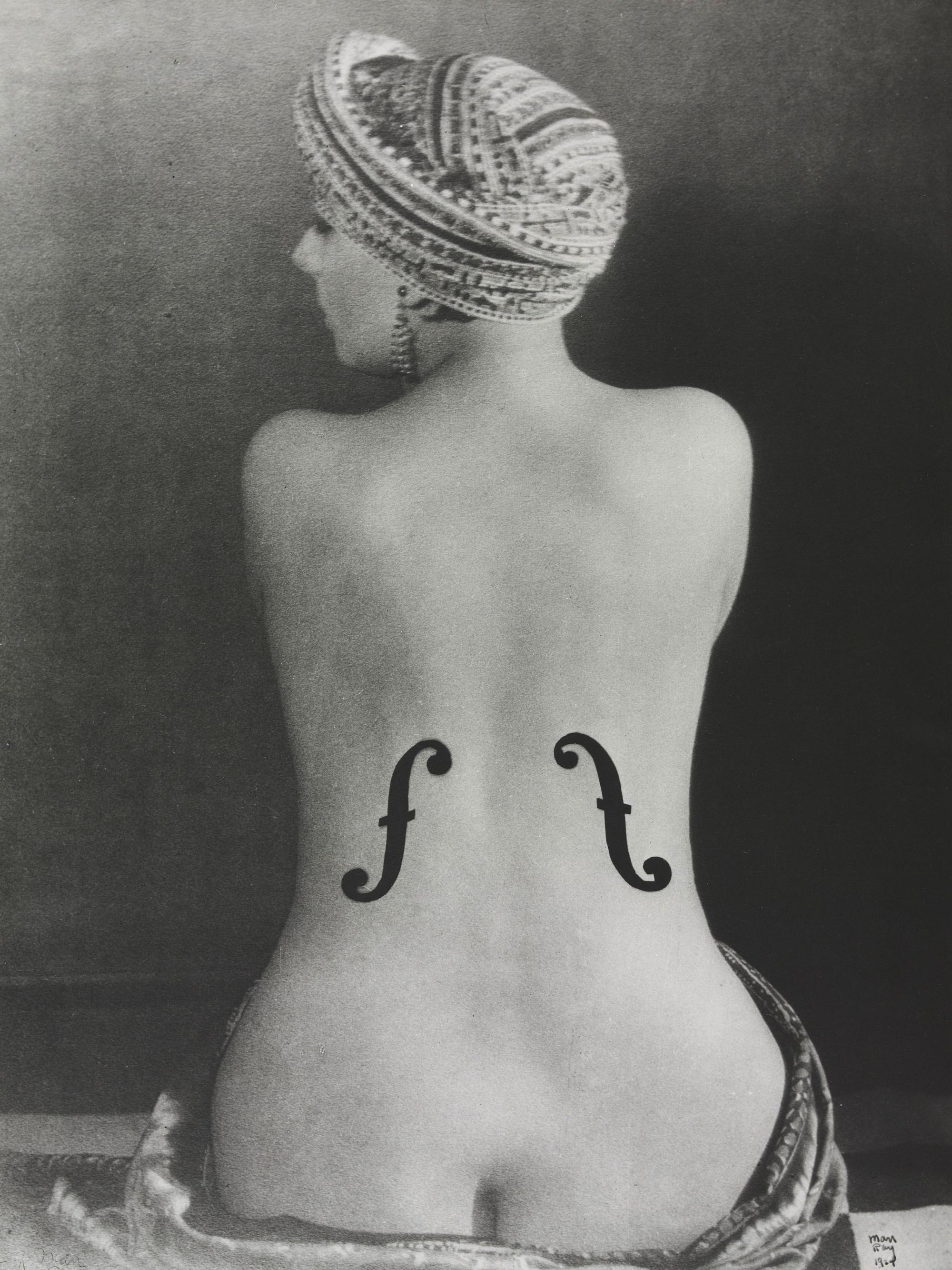 Eine Frau dreht uns den Rücken zu. Sie trägt Schalllöcher wie ein Cello.