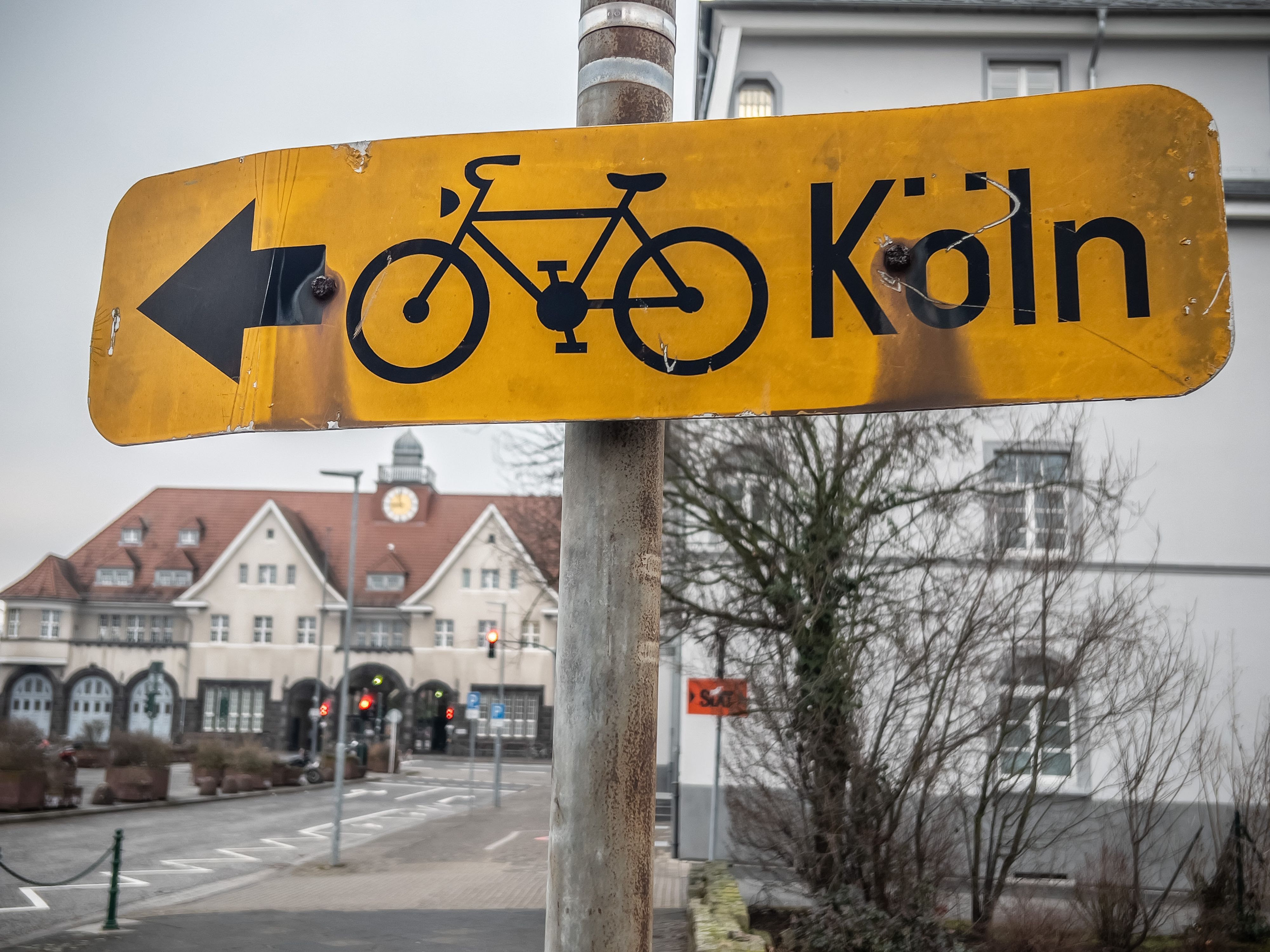 Die Idee, sichere Radwegen für Pendler nach Köln anzubieten, ist alt. Aus welchem Jahr dieses historische Radweg-Schild vor Tor 1 des Bayerwerks stammt, ist unklar. An einer Radpendlerroute wird seit Jahren geplant.
