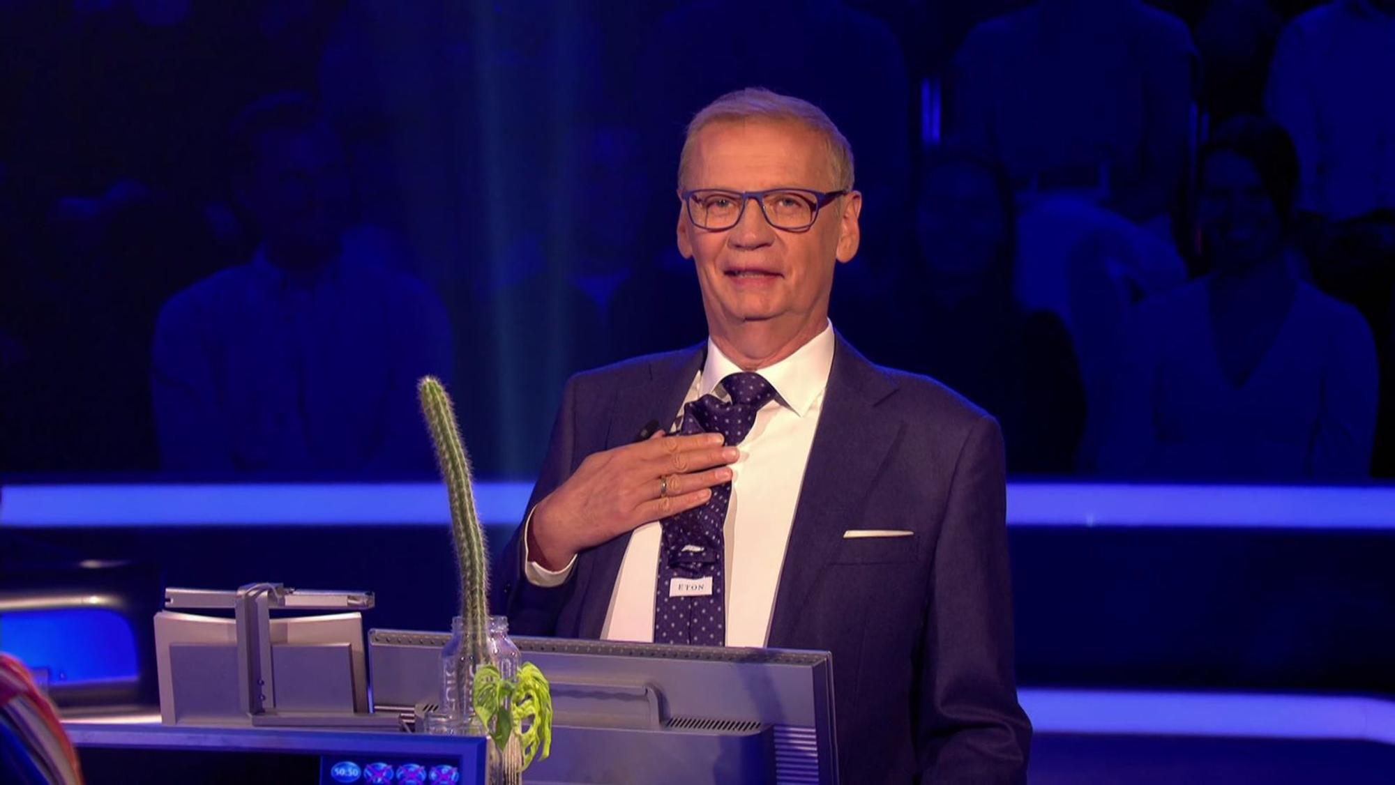 Schleichwerbung? Ach was! Günther Jauch konterkarierte bei „WSer wird Millionär?“ die werbeverhindernden Maßnahmen der Regie und hielt das Etikett seiner Krawatte grinsend in die Kamera. (Bild: RTL)