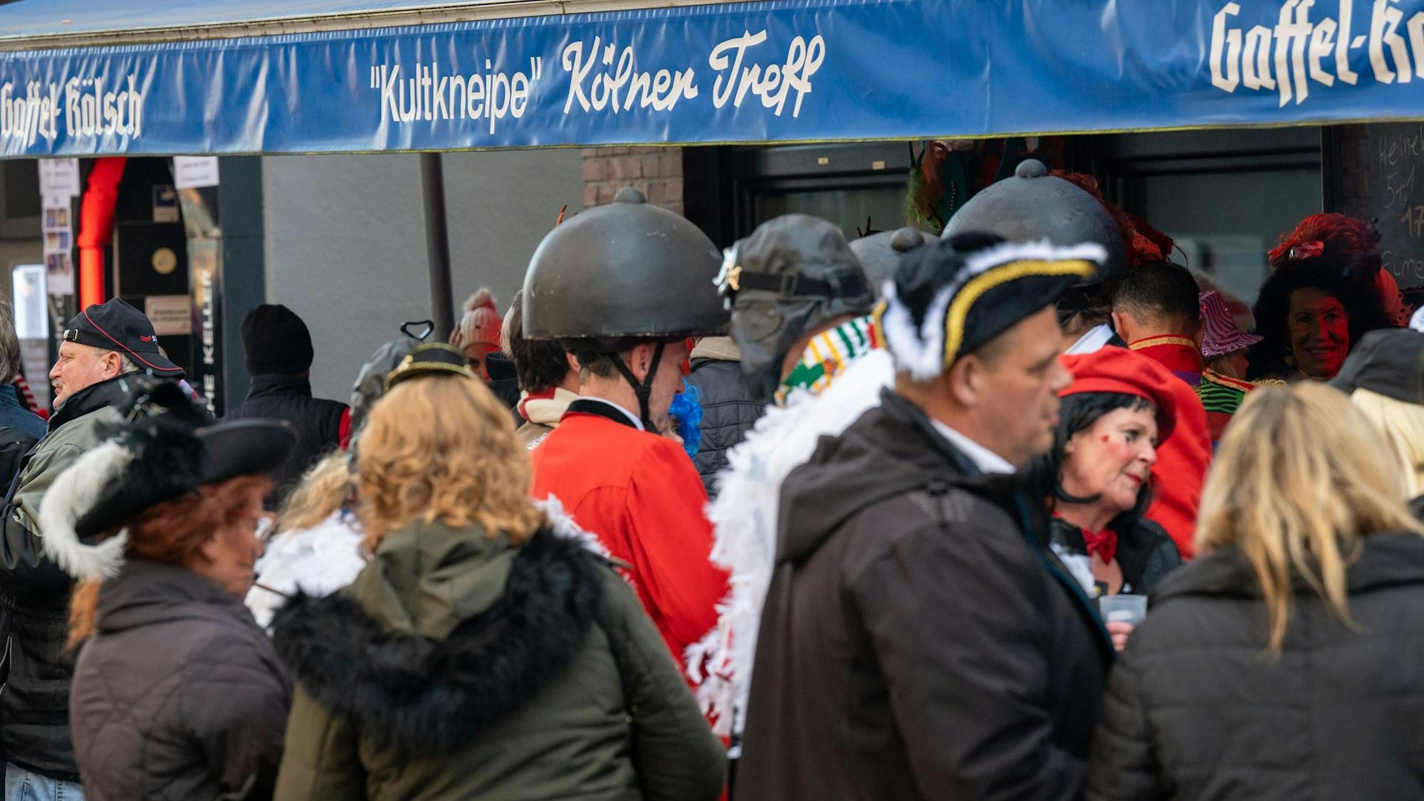 Kostümierte Menschen stehen vor der Kneipe „Kölner Treff".