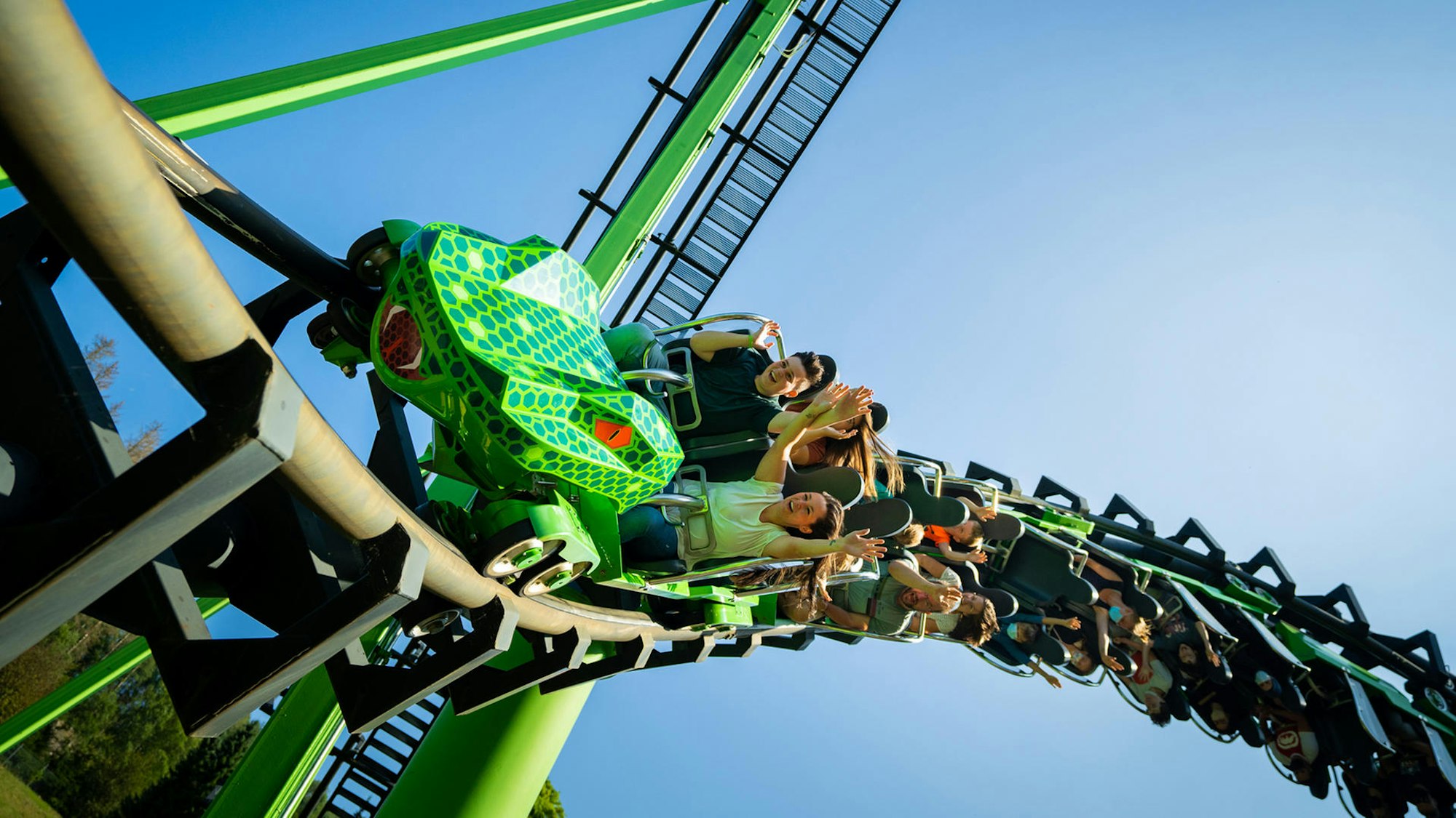 Menschen fahren auf einer Achterbahn, die wie eine Schlange aussieht.