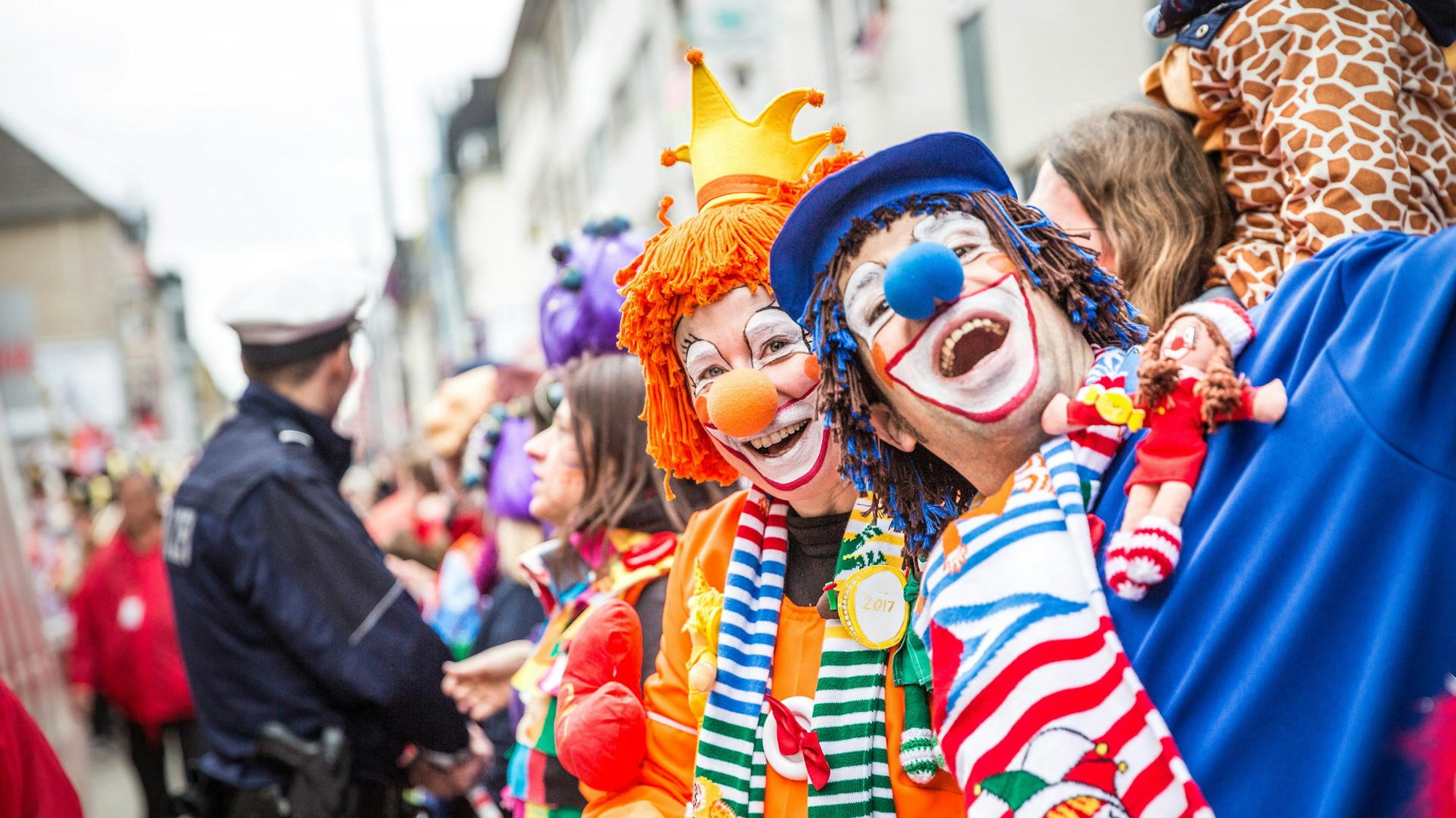 Zwei Menschen sind als Clowns verkleidet und lachen in die Kamera