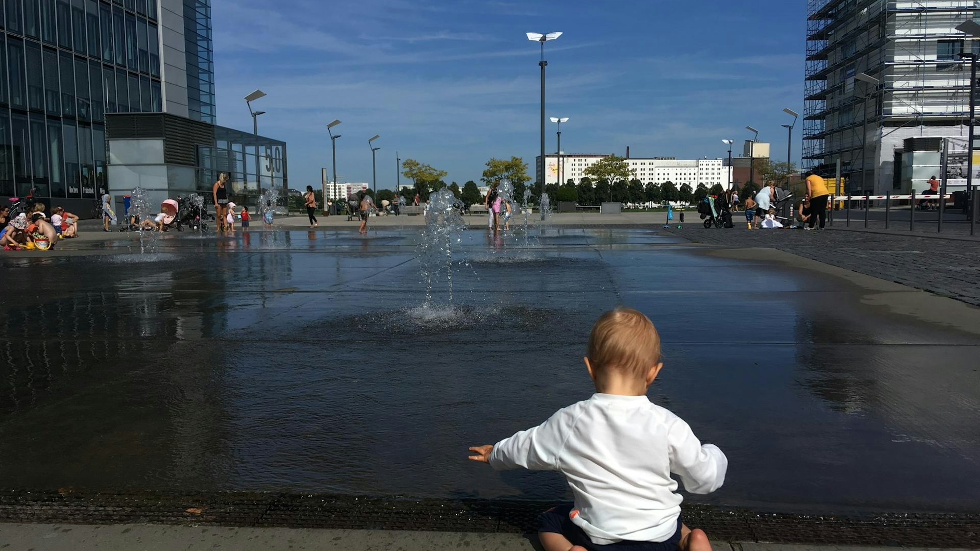 Ein Kind spielt am Wasserspielplatz im Rheinauhafen.