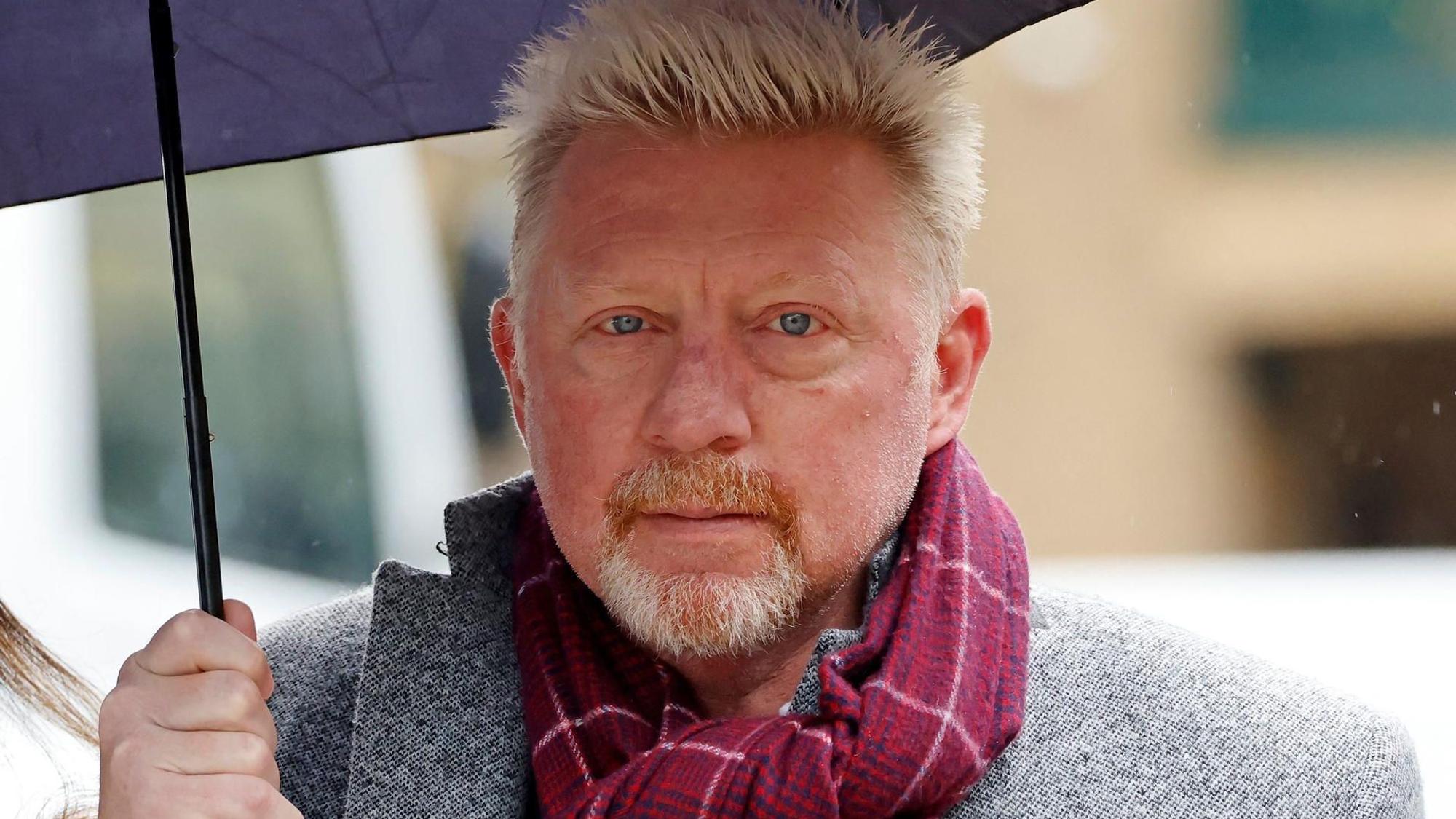 Boris Becker erscheint unter einem Schirm zu einem Termin.