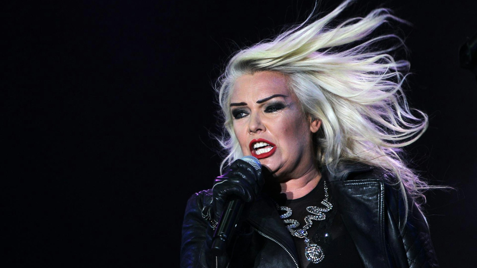 Kim Wilde singt in ein Mikro.