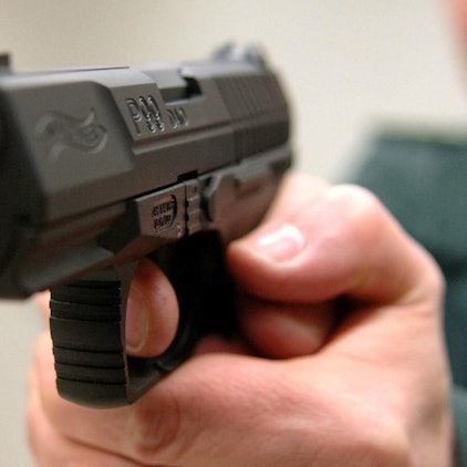 Ein Mann hält eine Waffe in der Hand.