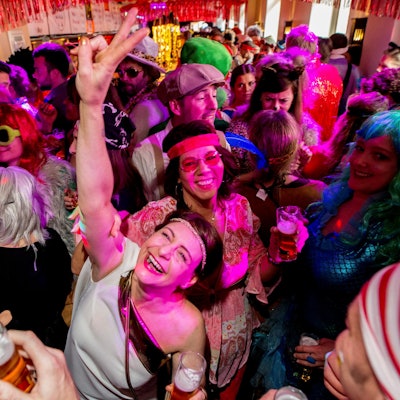 Menschen feiern bunt kostümiert beim Kneipenkarneval.
