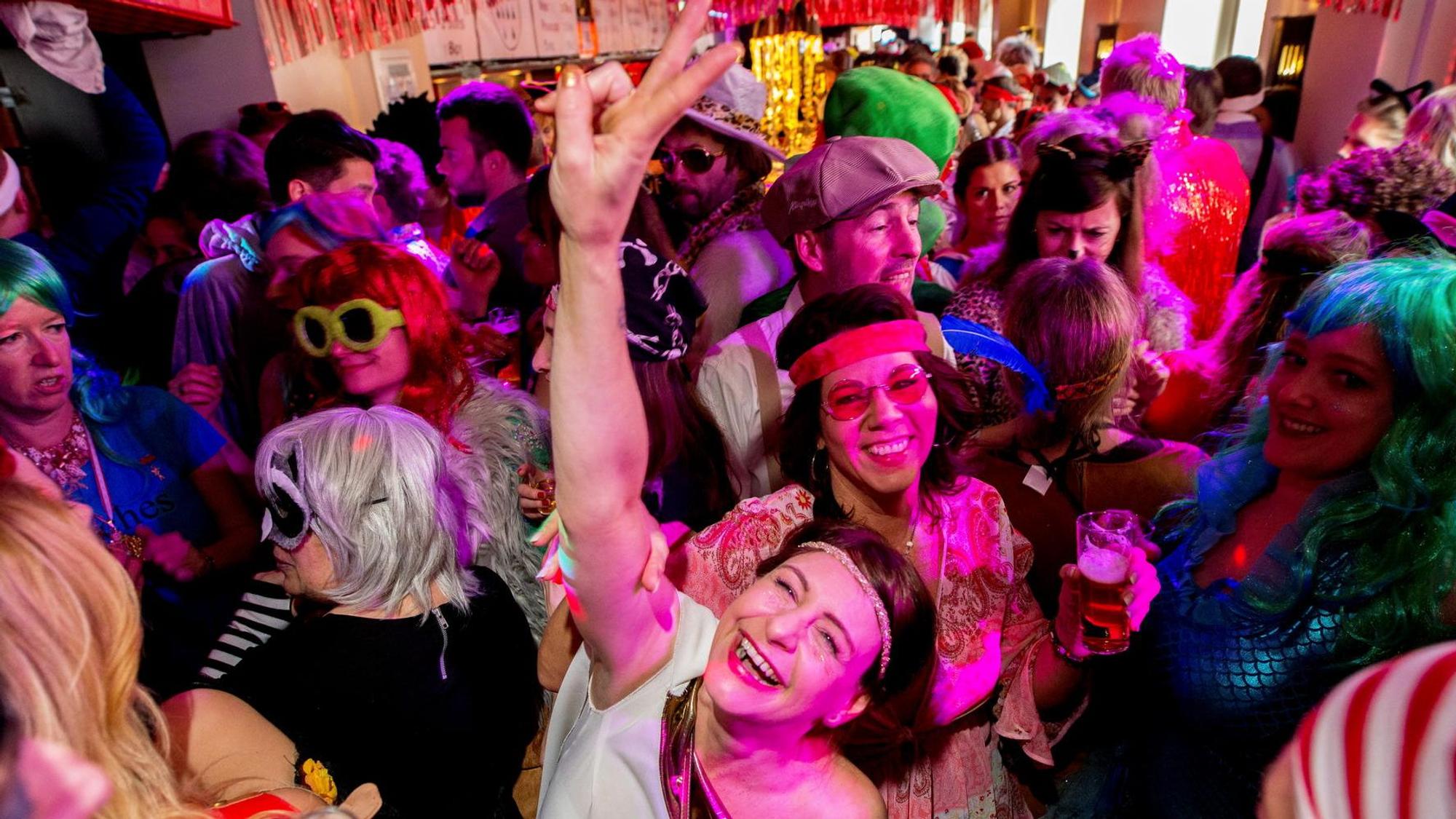 Menschen feiern bunt kostümiert beim Kneipenkarneval.