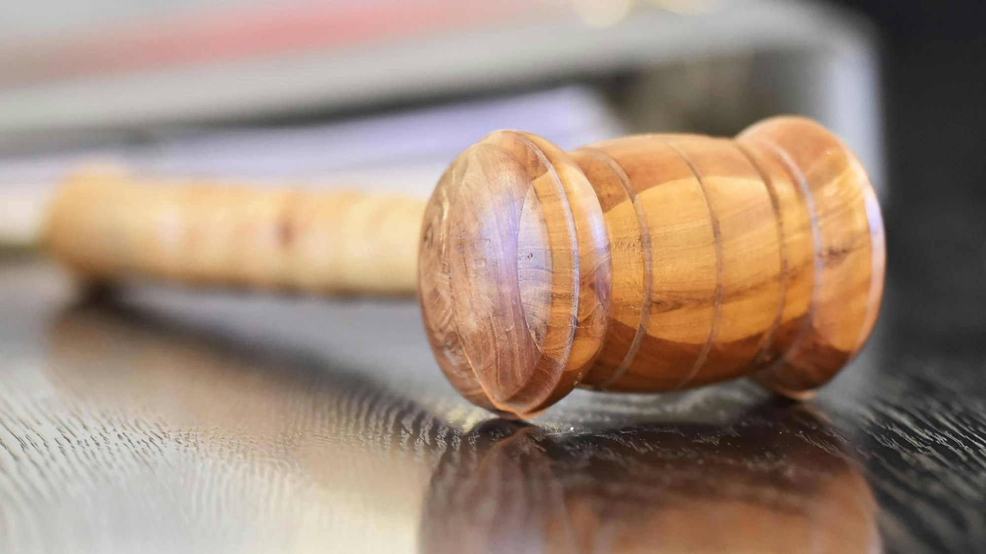 Ein Holzhammer liegt im Gericht auf dem Tisch eines Richters.