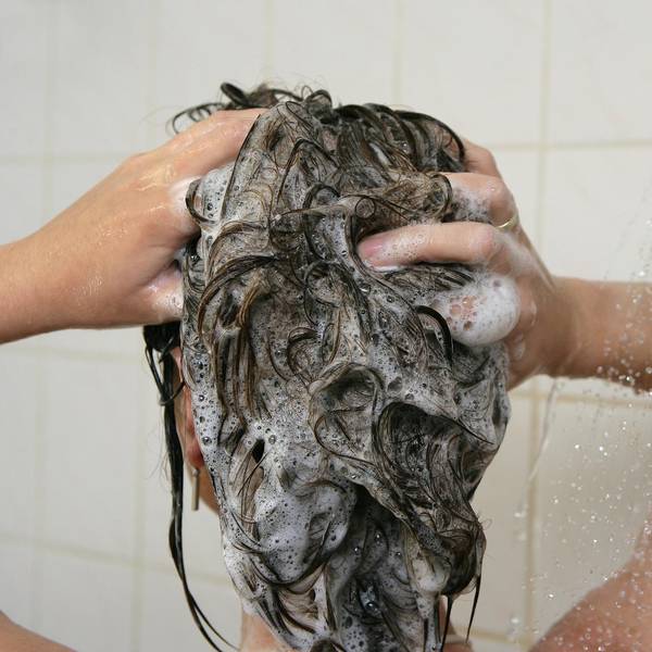 Frau wäscht sich die Haare