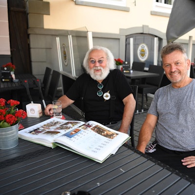 Wirt Jonny und sein Sohn Carsten Johnen sitzen in seinem Lokal an einem Tisch.