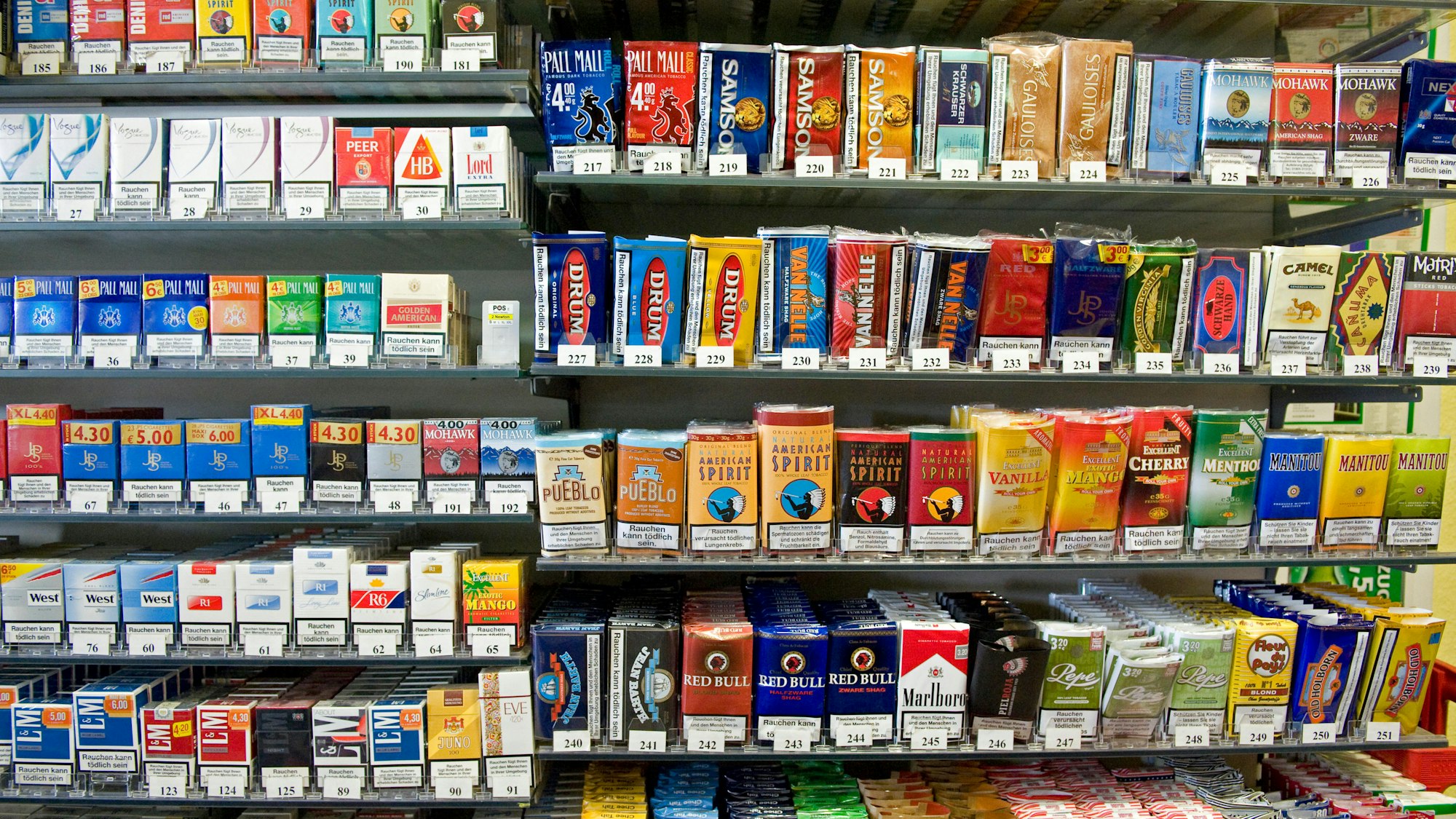 Das Bild zeigt ein Regal mit zahlreichen Zigarettenpackungen.