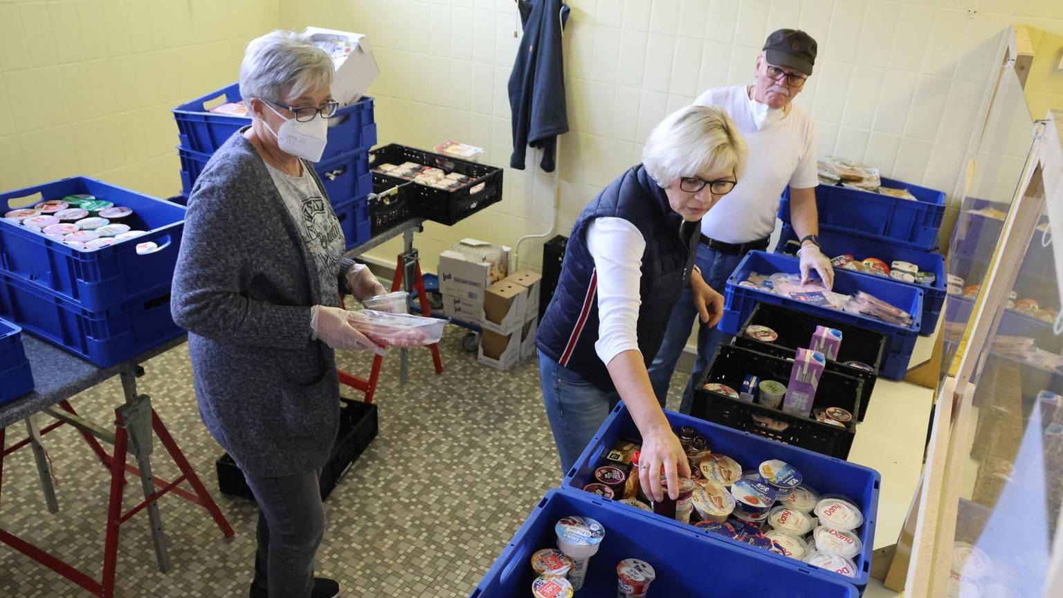 Frauen sammeln Lebensmitteln in Kisten.
