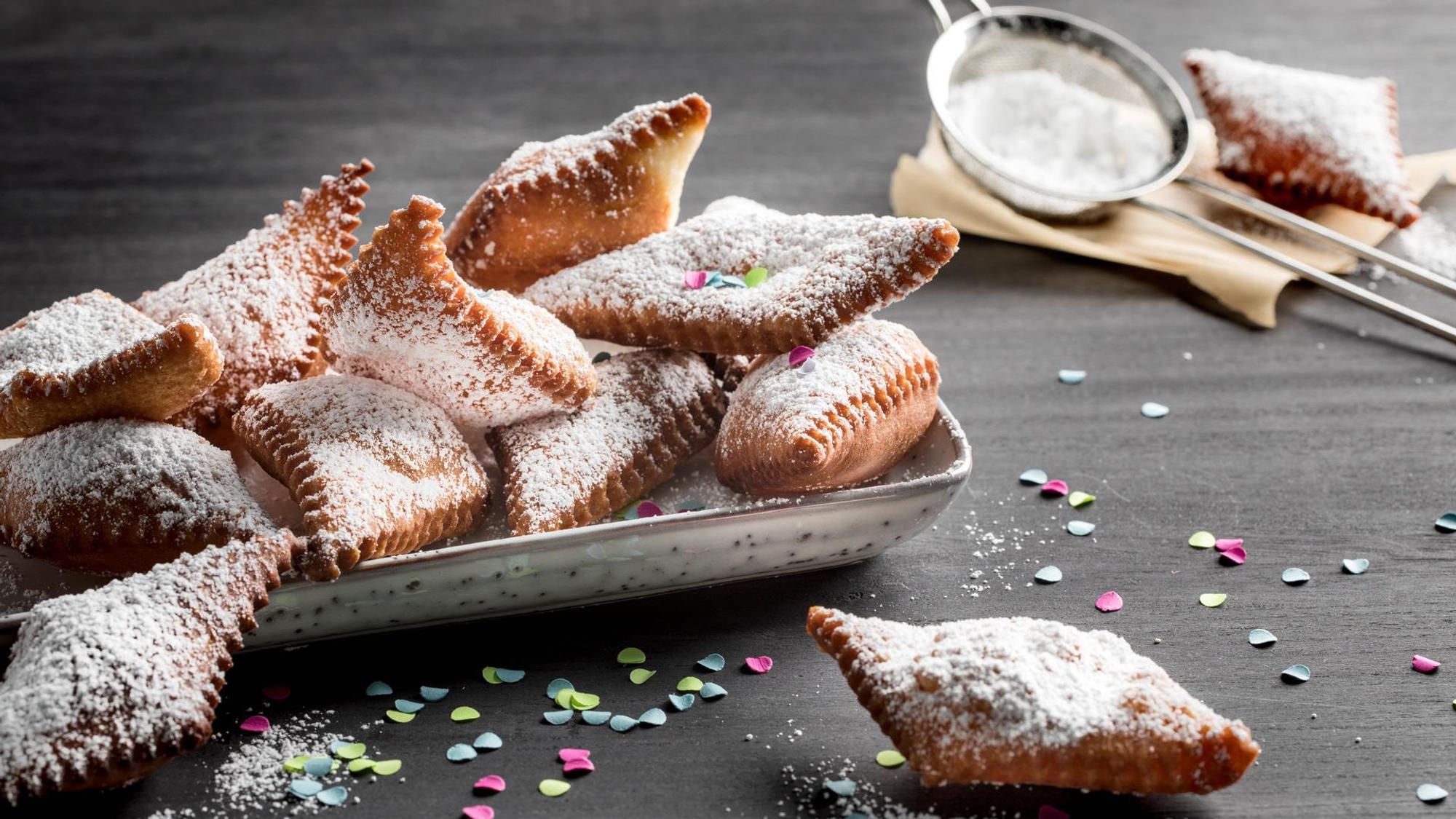 Puderzuckerbestäubte Muzen liegen in einem Schälchen angerichtet, Konfetti liegt drumherum