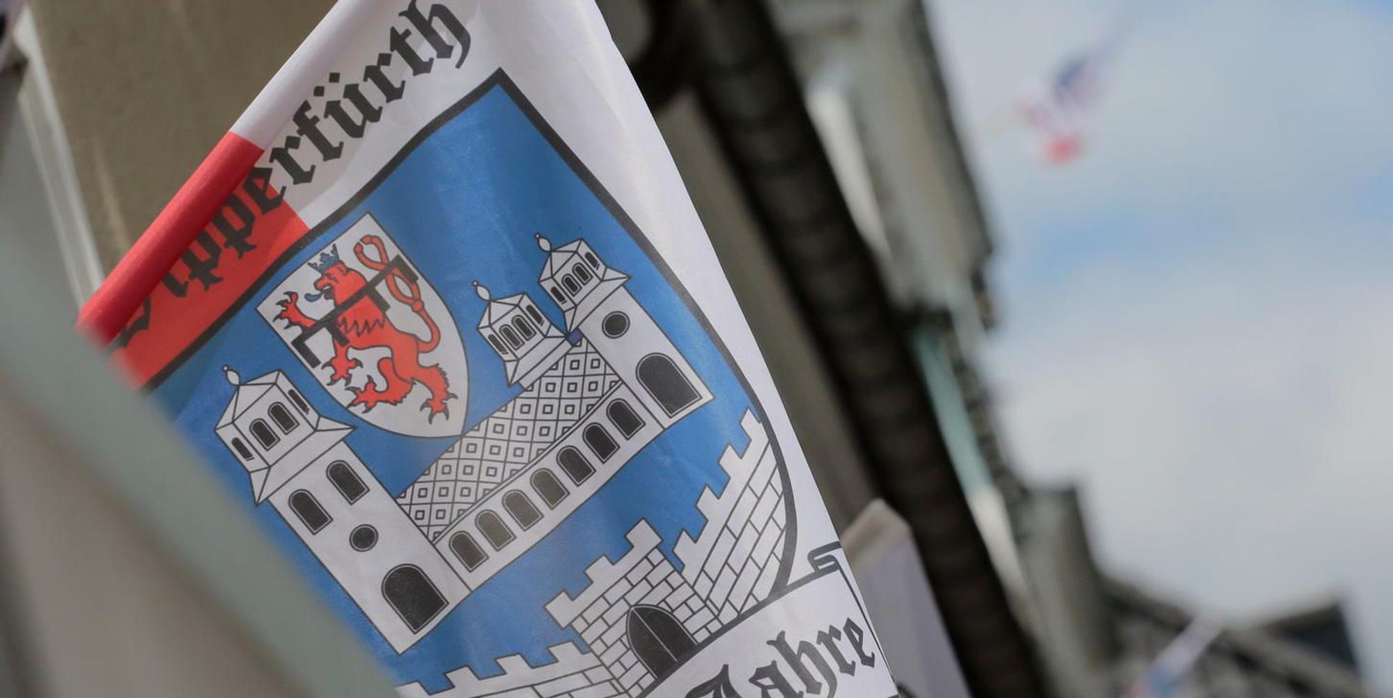 Die Stadtfahne von Wipperfürth weht aus dem Fenster eines Gebäudes.