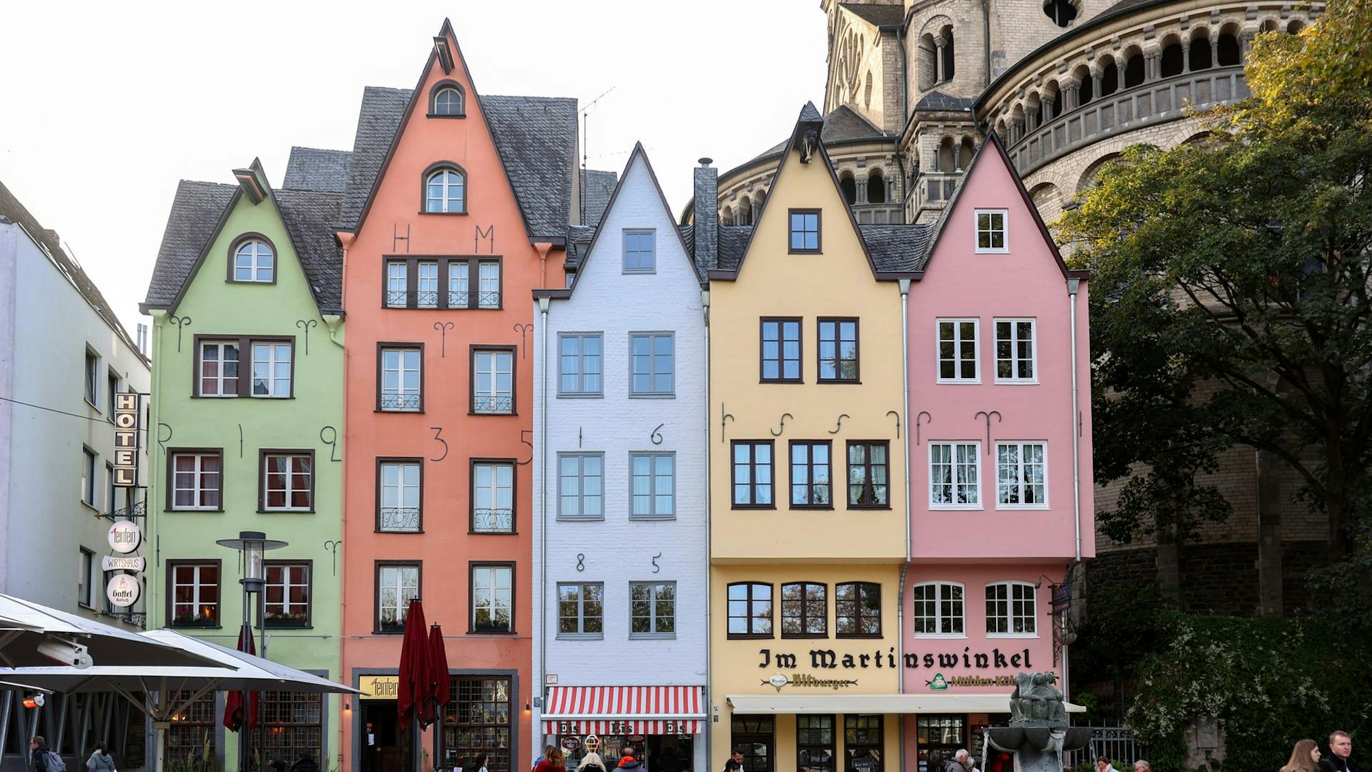 fünf Häuser in einer Reihe mit verschiedenfarbigen Frontseiten