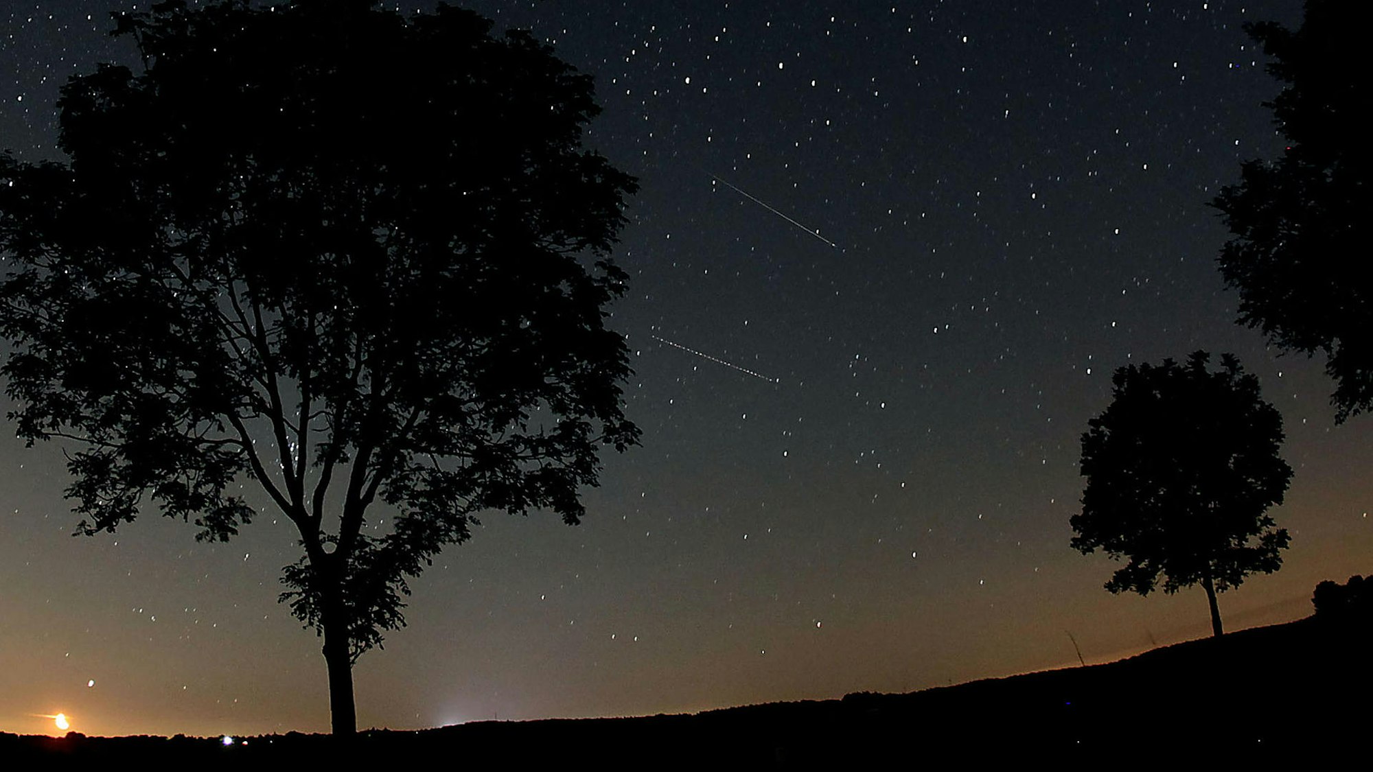 Zwei Sternschnuppen am Nachthimmel über der Eifel.