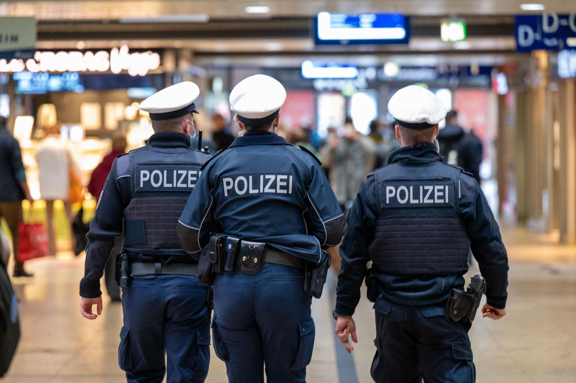 Drei Polizisten gehen durch den Kölner Hauptbahnhof.
