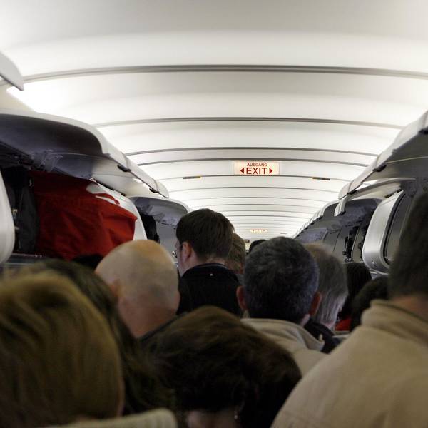 Passagiere stehen im Gang eines Flugzeuges