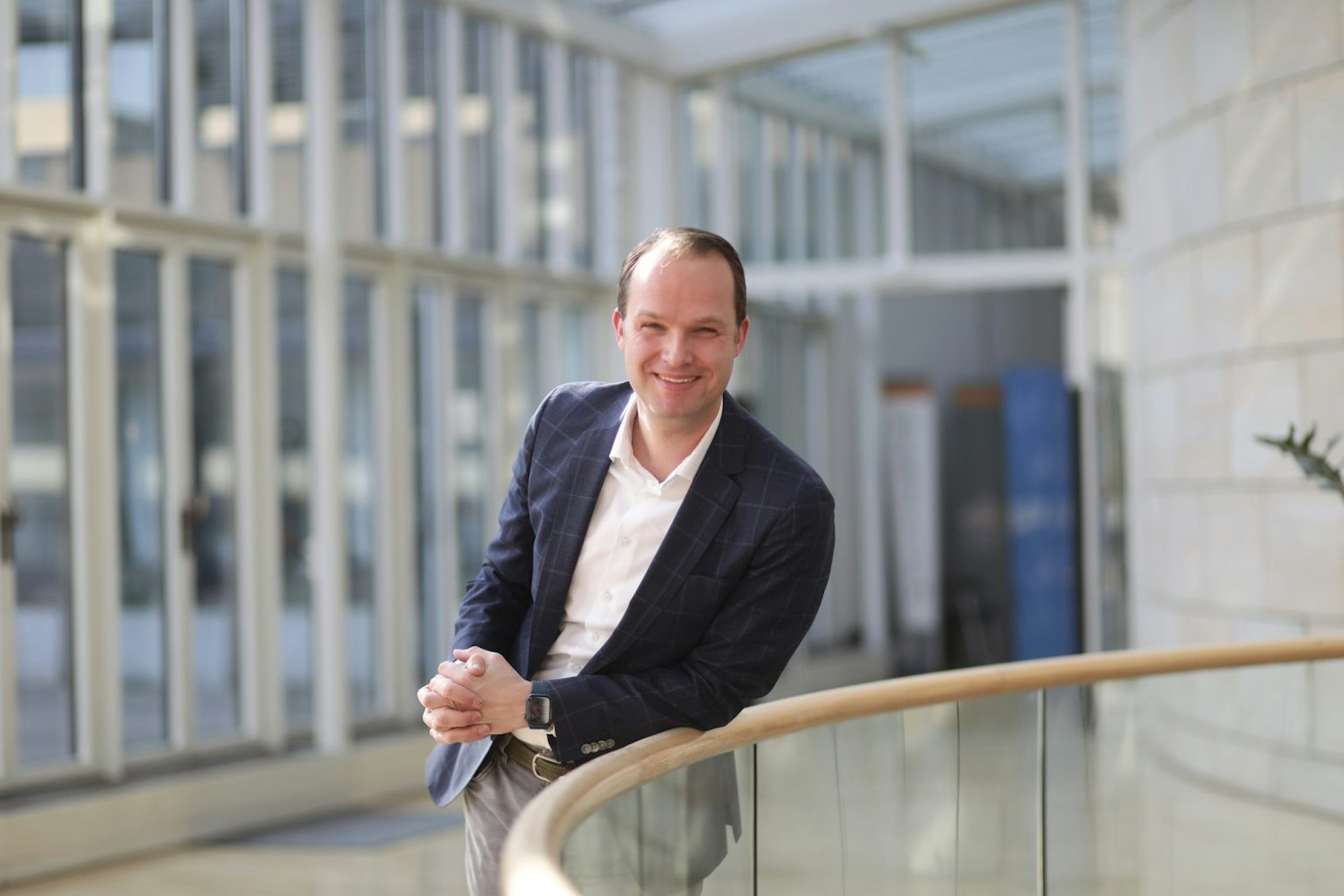 Marcel Hafke (FDP) steht im Büro in einem karierten Blazer und einem weißen Hemd