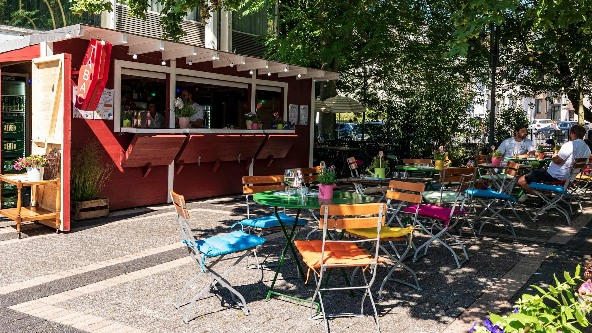 Bagatelle Biergarten mit Stühlen und bunten Kissen darauf.