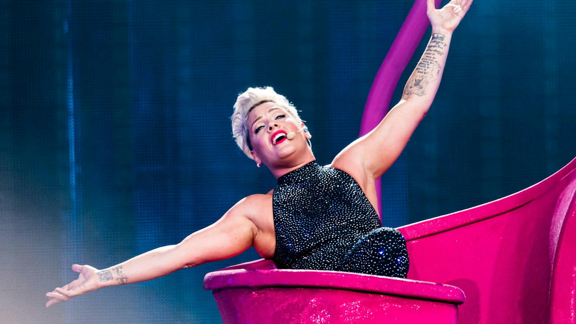 Pink reißt bei einem Auftritt die Arme hoch.