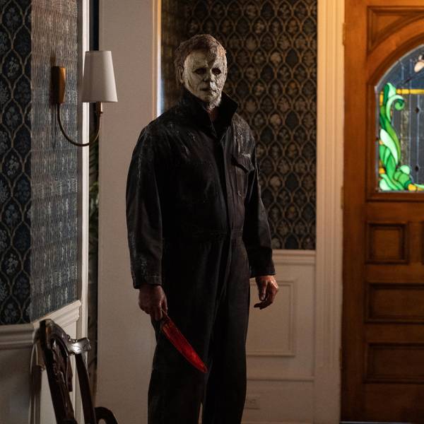 Die Hauptfigur der Halloween-Serie mit einem blutverschmiertem Messer steht im Flur eines Hauses. Er trägt seine berühmte, weiße Maske.