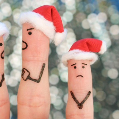Drei Finger dekoriert als Weihnachtsmänner spielen einen Streit nach.