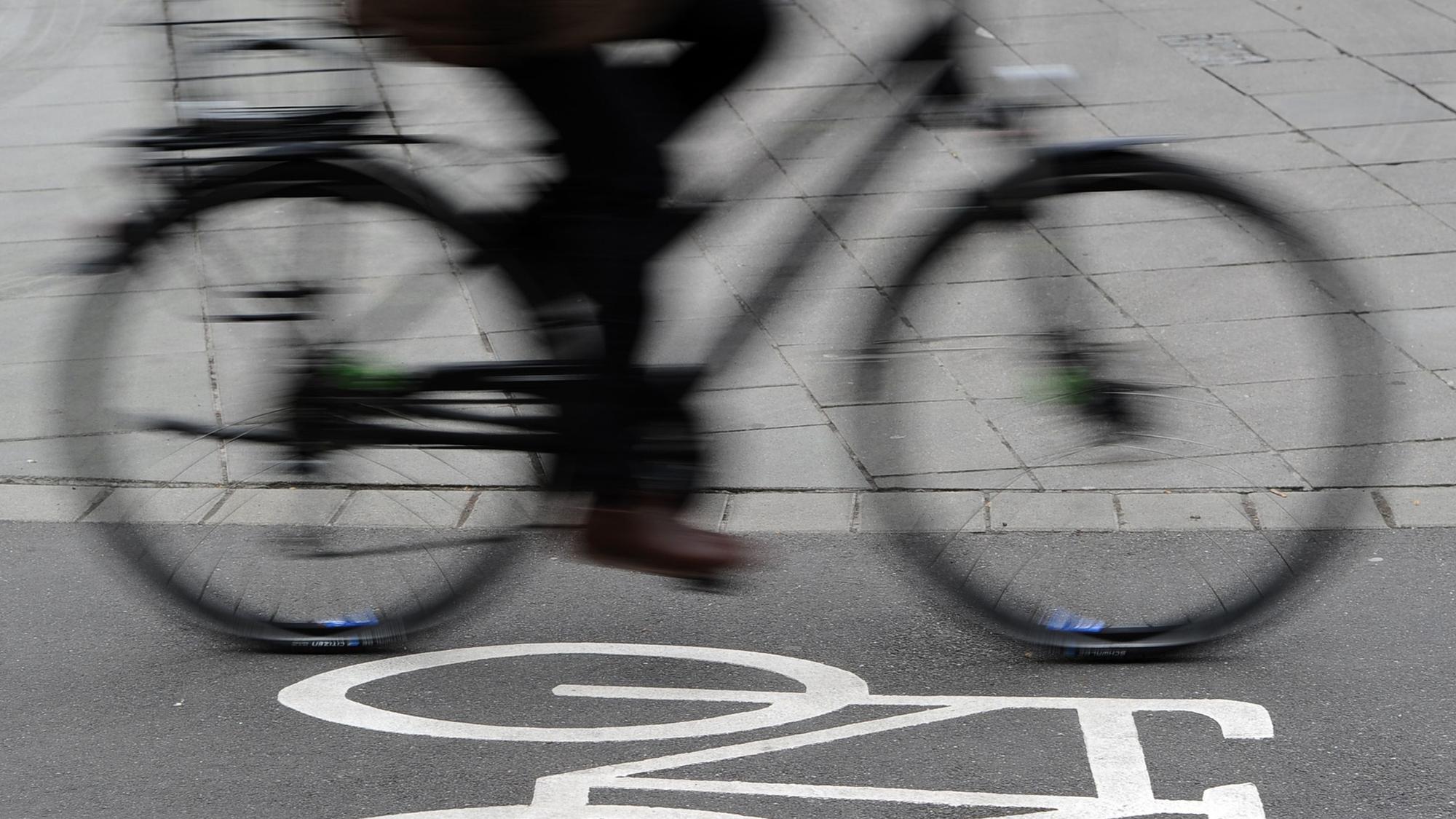 Das Foto zeigt einen Radfahrer auf einem Radweg, der mit einem Fahrradsymbol gekennzeichnet ist.