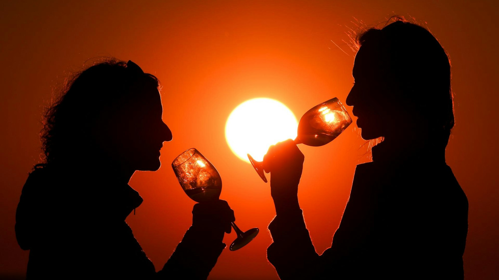 Frauen trinken Wein in der Abendsonne.