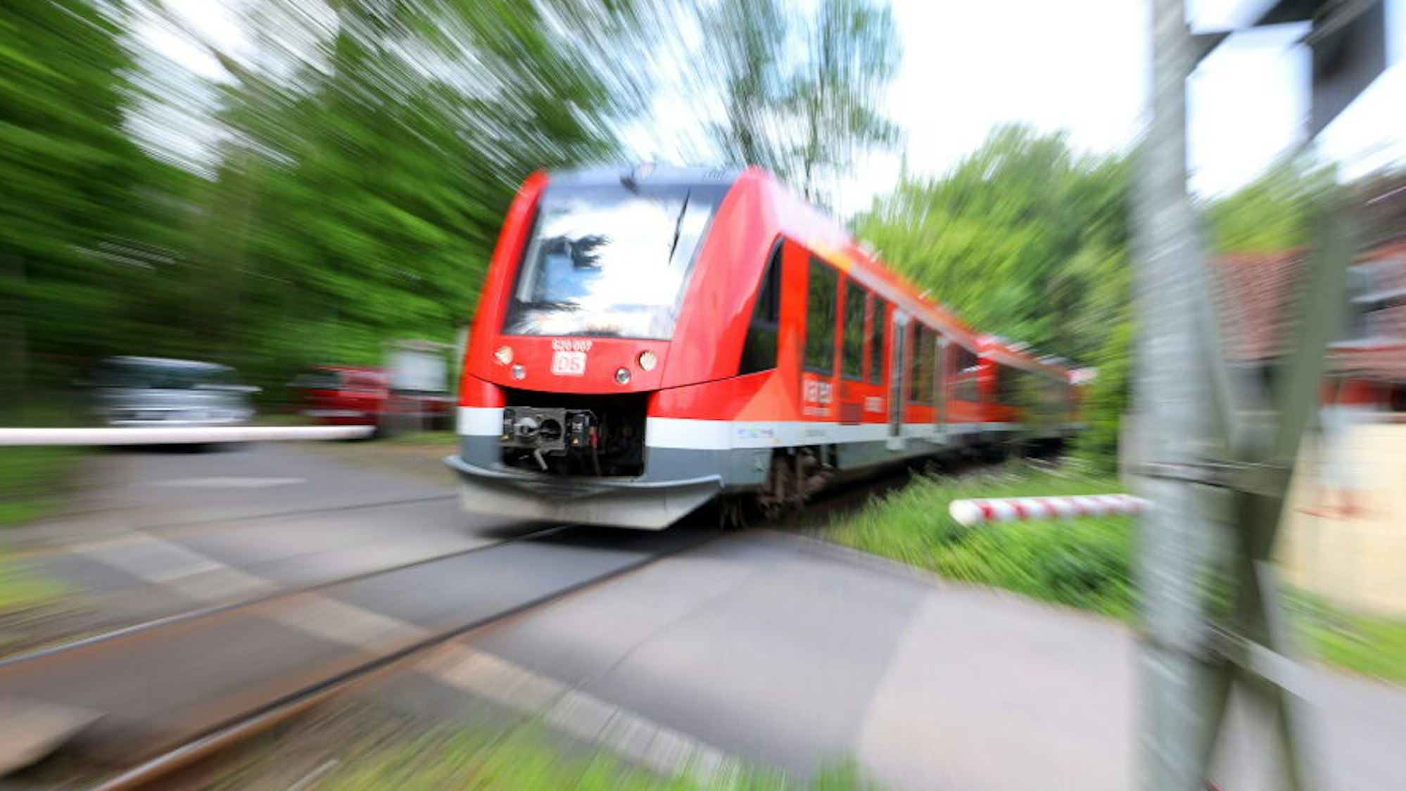 Ein Zug der RB25 fährt an einer Schranke vorbei.