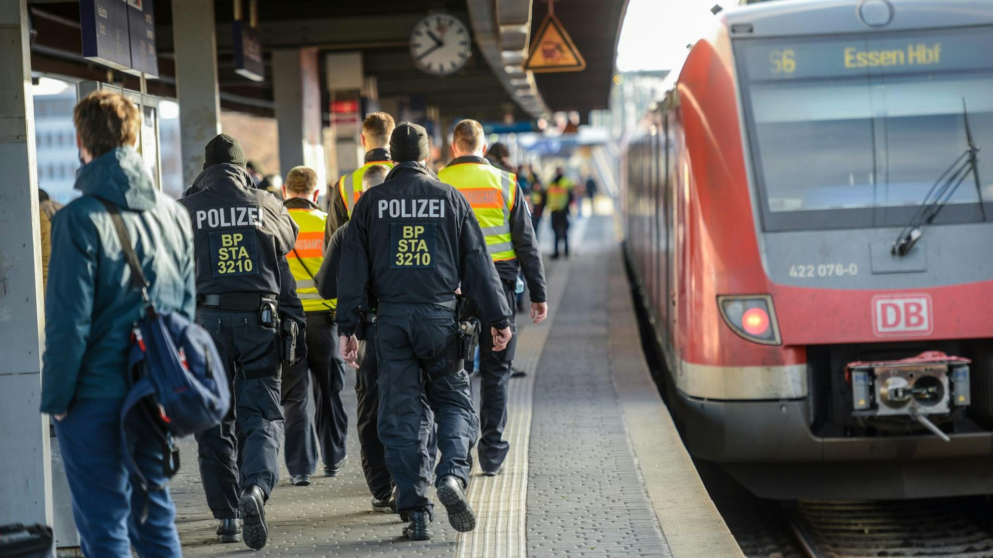 Mehrere Beamte der Bundespolizei gehen an einem Bahnsteig am Bahnhof Messe/Deutz entlang.