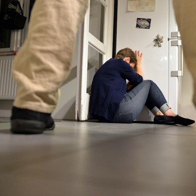 Häusliche Gewalt Beine Mann Frau zusammengekauert