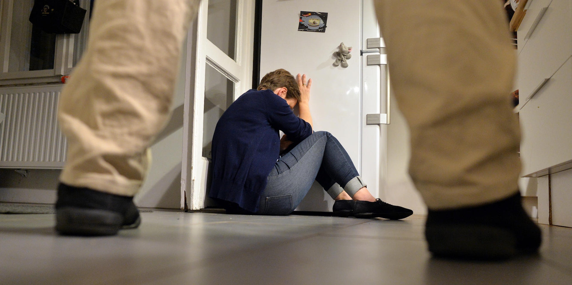 Häusliche Gewalt Beine Mann Frau zusammengekauert