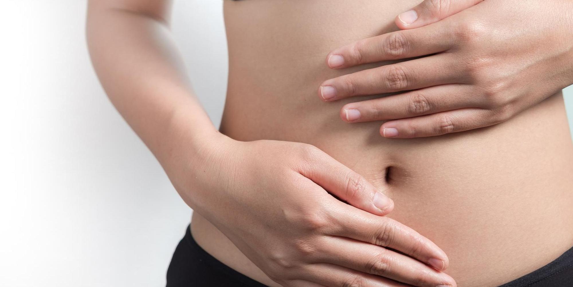 Junge Frau hält ihren Bauch