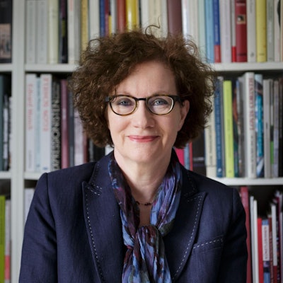 Hannelore Fischer steht vor einer Bücherwand.