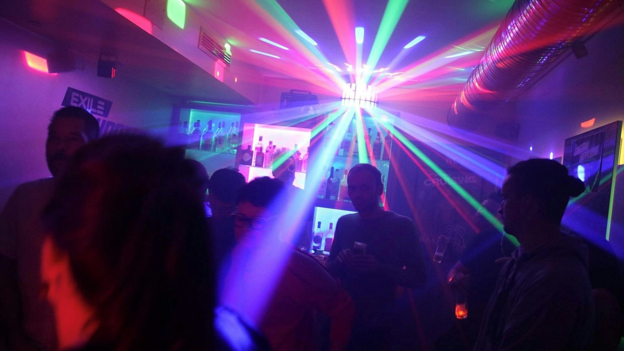 Innenansicht des Exile, im Hintergrund stahlt ein Leuchter die tanzenden Gäste an.