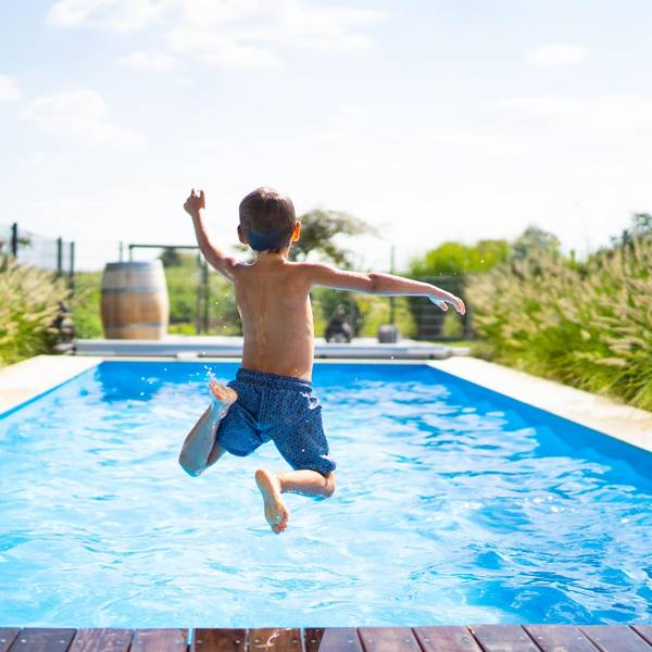 Junge-springt-mit-Anlauf-in-einen-Swimmingpool