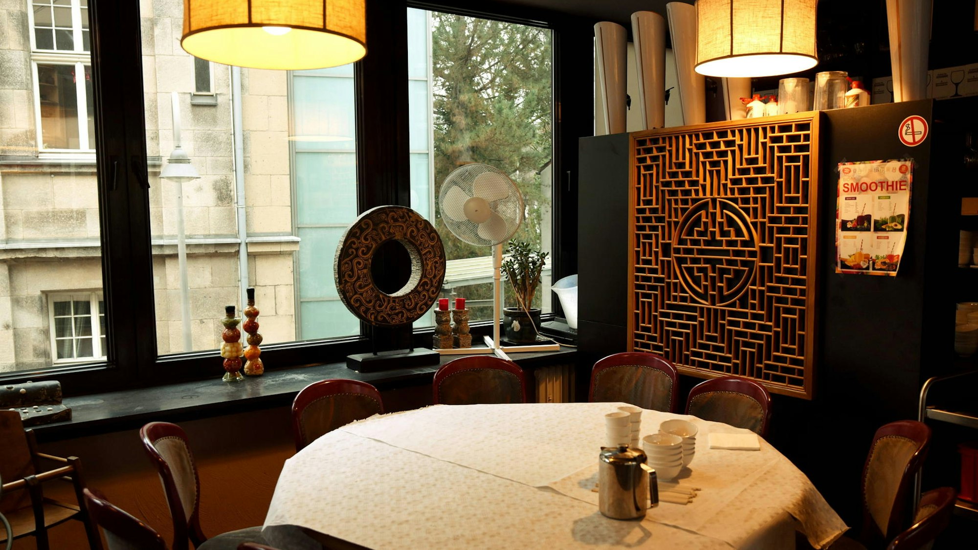 Tisch mit weißer Tischdecke, darüber zwei Lampen