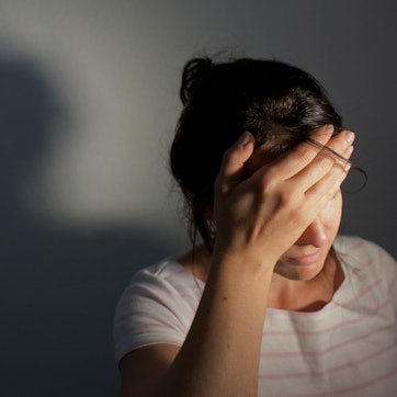 Frau hält sich den Kopf und hat Kopfschmerzen