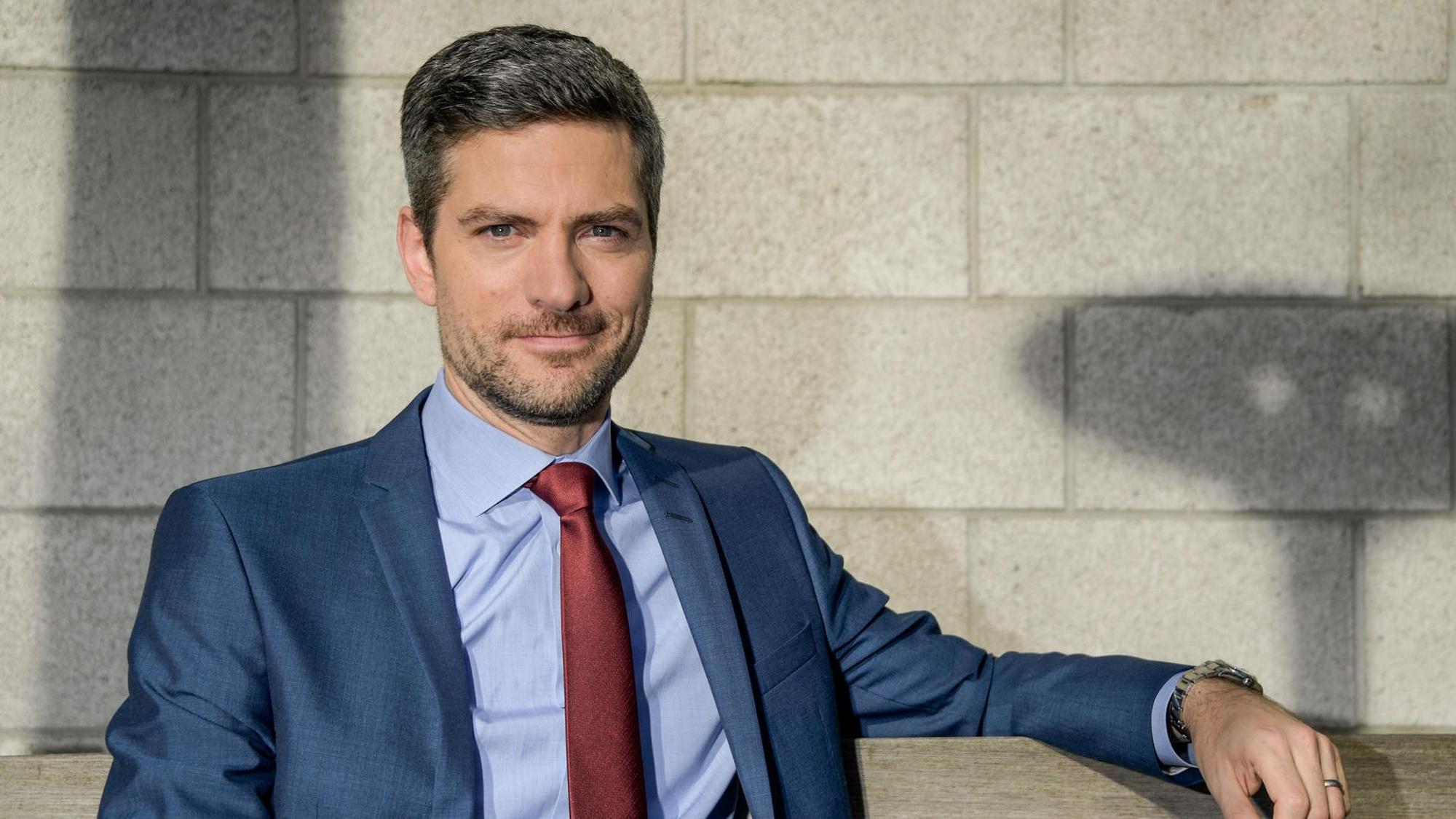 Ingo Zamperoni sitzt auf einer Bank.