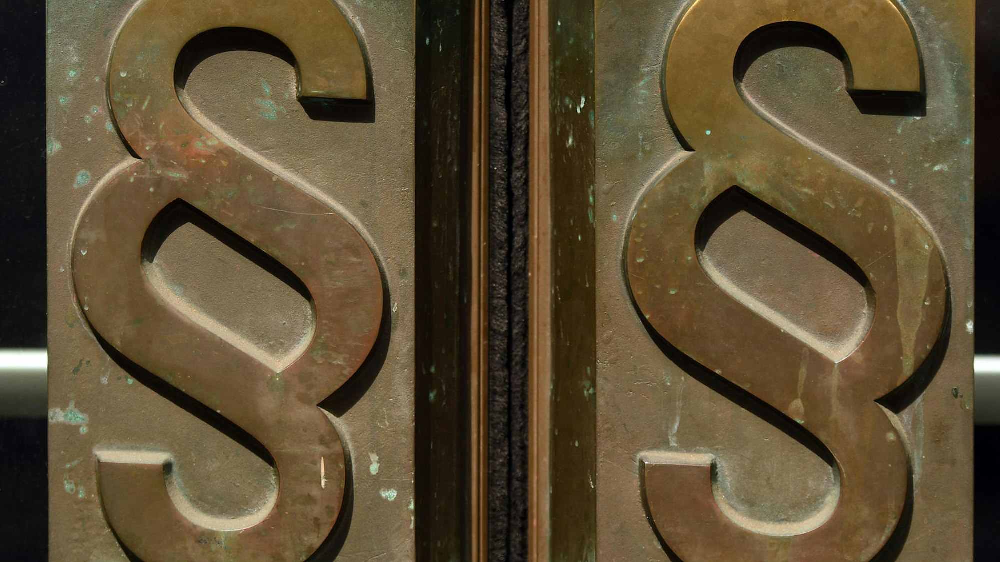 Das Paragraf-Zeichen an einem Gerichtseingang.