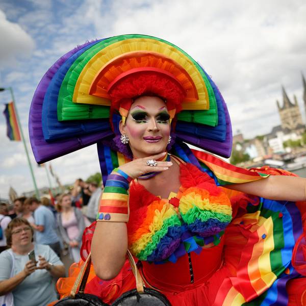 Ein bunt gekleideter Mensch beim CSD im Kostüm.
